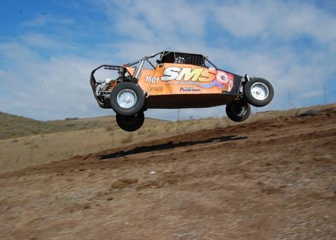 1992 Ford Explorer - An off-road buggy with the number 1601 and SMS branding takes flight against a blue sky.