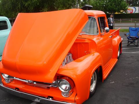 1993 Ford Taurus - This classic orange 1956 Ford F-100 pickup truck is displayed with its hood open, revealing the engine bay.