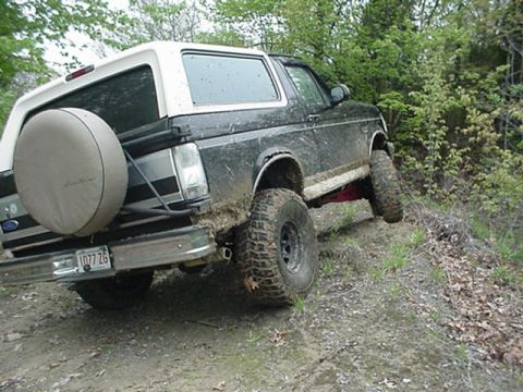 1993 Ford Bronco - This 1993 Ford Bronco navigates a muddy, wooded trail with its rear 3/4 view prominent.