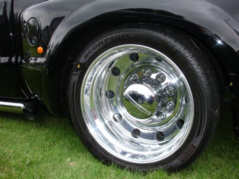 1993 Ford Taurus - Chrome wheel and tire detail on a black vehicle, with a reflection in the hubcap.