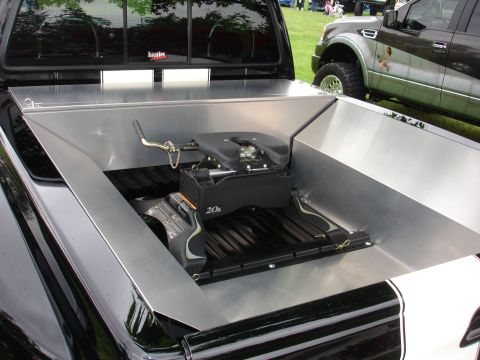 1993 Ford Taurus - A fifth wheel hitch is mounted in the bed of a black pickup truck, with another truck visible in the background.
