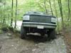 1993 Ford Bronco - This 1993 Ford Bronco is navigating a rough, unpaved path surrounded by trees.