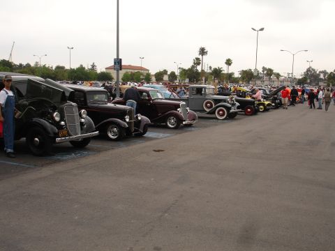 1993 Ford Taurus - A collection of vintage automobiles are parked in a lot, with a black 1935 Ford visible in the foreground.