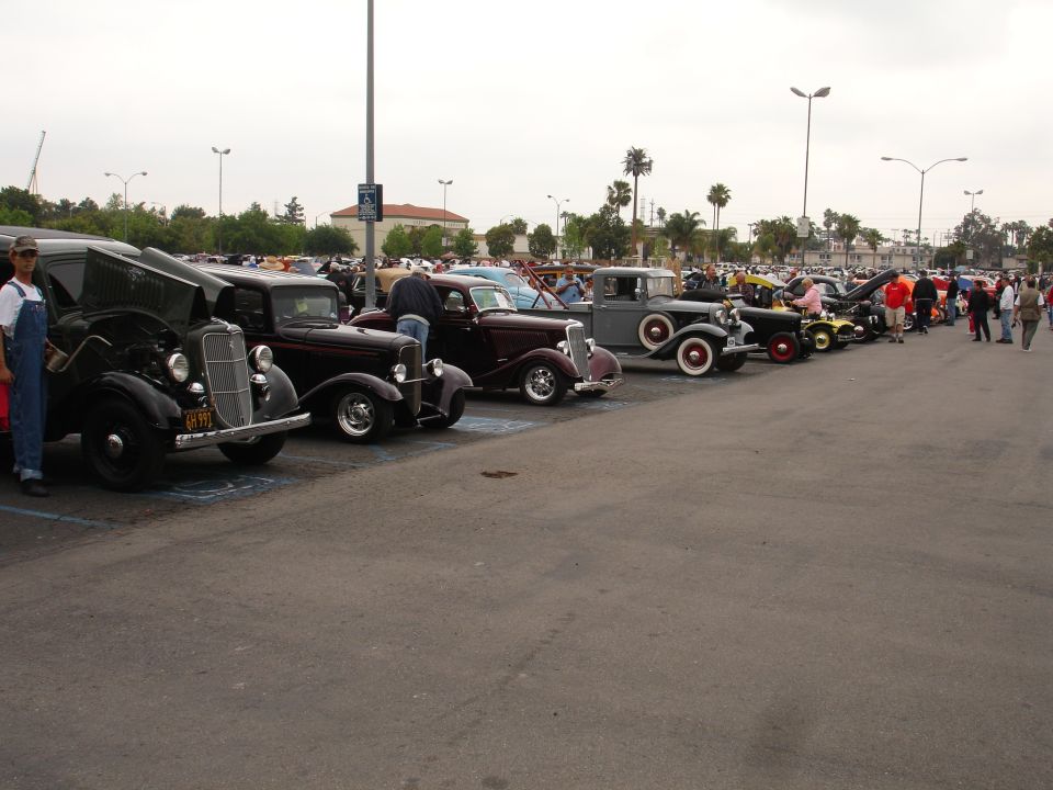 Side view of a line of classic cars, including a black 1935 Ford