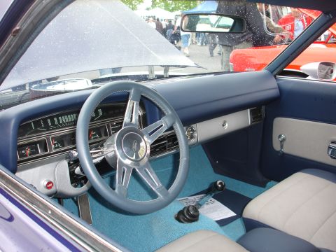 1993 Ford Taurus - The interior of a classic car, a blue dashboard and steering wheel, with the hood open.
