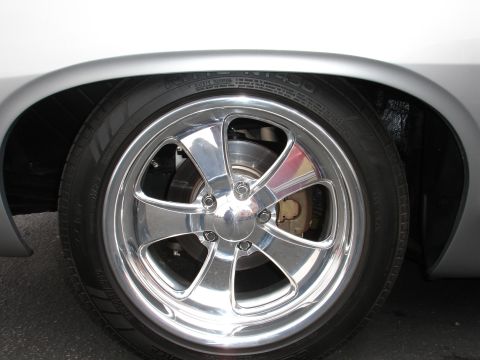 1993 Ford Taurus - Close-up of a shiny chrome wheel and tire, revealing the brake system behind the spokes.