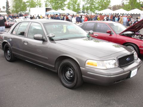 1993 Ford Taurus - Two Ford Crown Victorias are parked at an outdoor event.