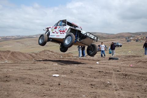 1992 Ford Explorer - This off-road buggy is airborne during a jump event with spectators present.