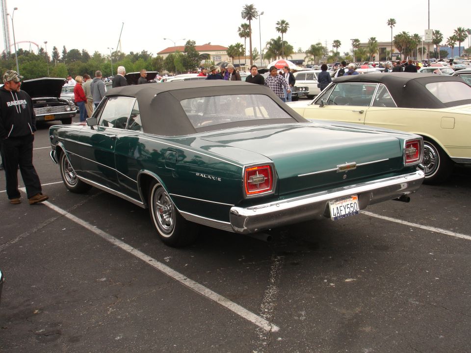 Green 1965 Ford Galaxie convertible rear view with black top