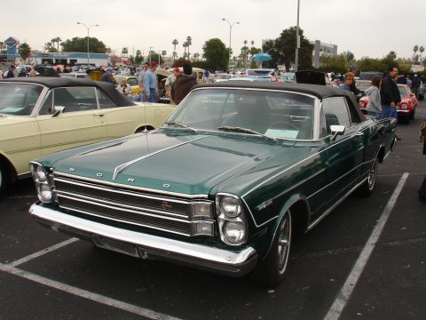 1993 Ford Taurus - Green 1965 Ford Galaxie 500 convertible at a car show, with other vehicles present.
