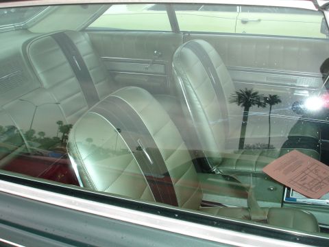 1993 Ford Taurus - The interior of a classic car features two-tone seats and a document visible on the center console.