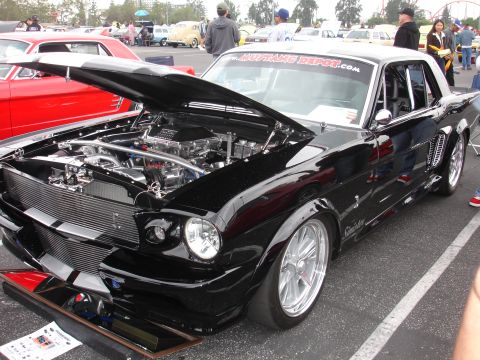 1993 Ford Taurus - Custom 1965 Ford Mustang with a supercharged engine on display at a car show.