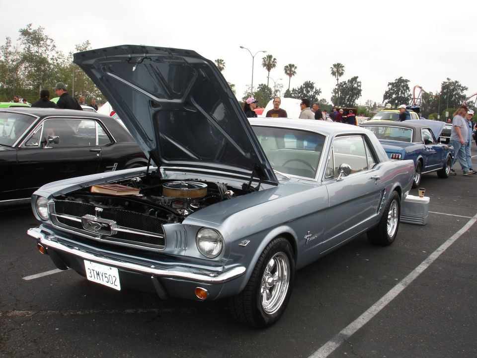 Silver 1965 Ford Mustang with hood open, showing engine. License plate 3TMY502