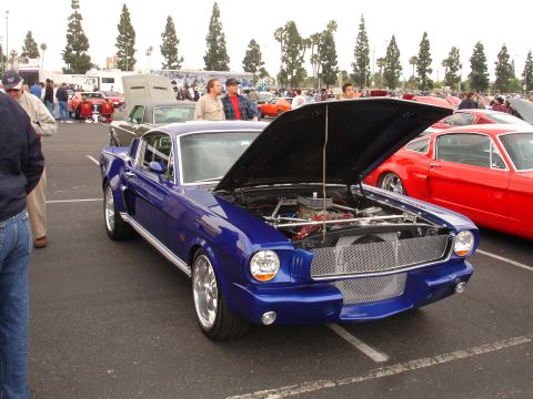 1993 Ford Taurus - A blue 1967 Ford Mustang Fastback is displayed with its hood open at an outdoor car show.
