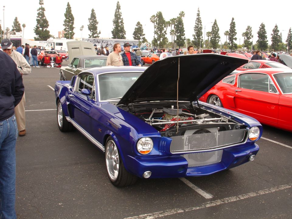Blue 1967 Ford Mustang Fastback with hood open, parked next to a red car