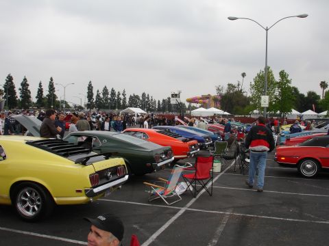 1993 Ford Taurus - A gathering of vintage automobiles on a cloudy day, with spectators observing the vehicles.