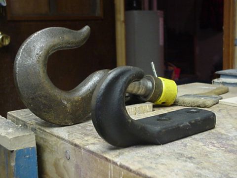 1993 Ford Bronco - Close-up of two heavy-duty tow hooks on a workbench.