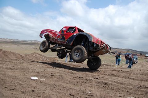 1992 Ford Explorer - A custom-built off-road truck soars through the air during a race event.