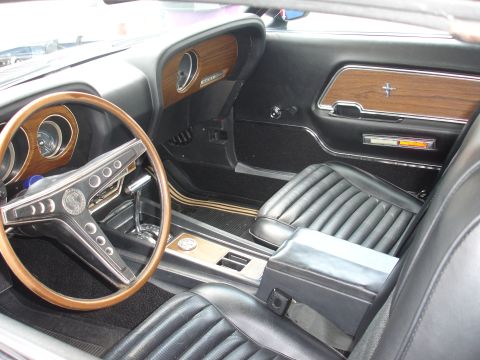 1993 Ford Taurus - The interior of a classic Mustang features wood grain accents and a Shelby Cobra emblem on the steering wheel.