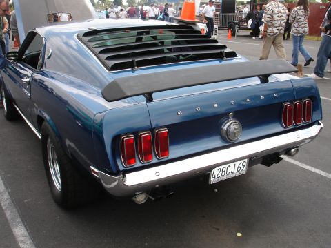 1993 Ford Taurus - Rear view of a blue 1969 Ford Mustang with a spoiler and rear window louvers.