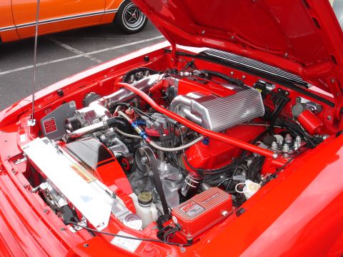 1993 Ford Taurus - The engine bay of a red car is shown with various performance upgrades, including an MSD ignition box and a polished intake manifold.