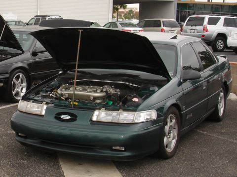 1993 Ford Taurus - 1993 Ford Taurus with its hood open, revealing the engine and a strut tower brace installed.