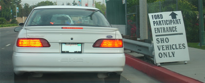 1993 Ford Taurus - White 1993 Ford Taurus SHO seen from the rear, with a sign indicating 'SHO VEHICLES ONLY'.