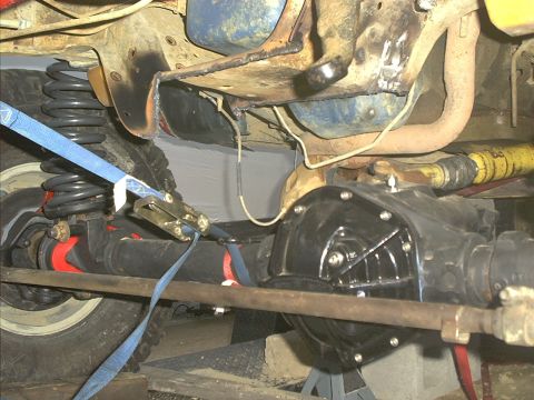 1986 Ford Bronco - Undercarriage view shows the rear axle assembly and suspension system of a vehicle.