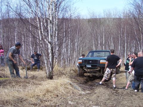 1996 Ford Bronco - People watch as a 1996 Ford Bronco gets stuck in the mud during an off-road excursion.