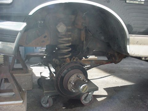 1993 Ford Bronco - Front suspension and brake assembly of a 1993 Ford Bronco undergoing maintenance.