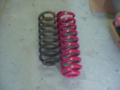 1993 Ford Bronco - A pair of coil springs, one old and one freshly painted, are displayed side-by-side.