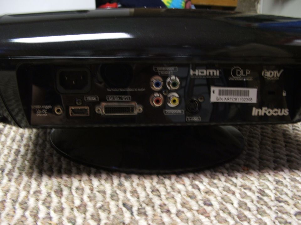 Projector rear panel with HDMI, DVI, and component video inputs, and InFocus branding