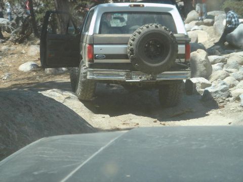 1994 Ford Bronco - This 1994 Ford Bronco is seen from the rear with its driver door open, navigating rocky terrain.