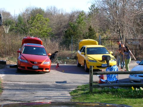 1994 Ford Probe - Two sedans are parked outdoors with their hoods open, with people nearby.