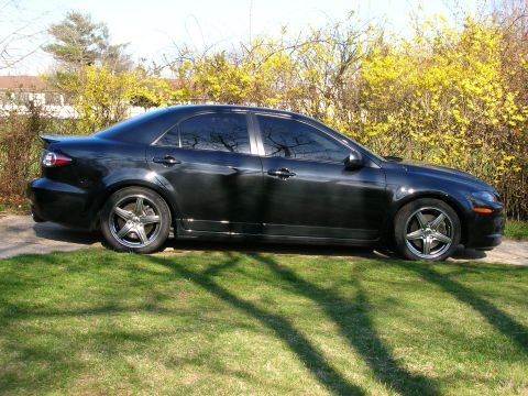 1994 Ford Probe - A black sedan with tinted windows and aftermarket wheels is parked on a grassy lawn.