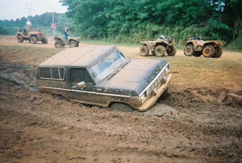 1978 Ford Bronco - This vehicle is stuck in the mud, with other off-road vehicles in the background.