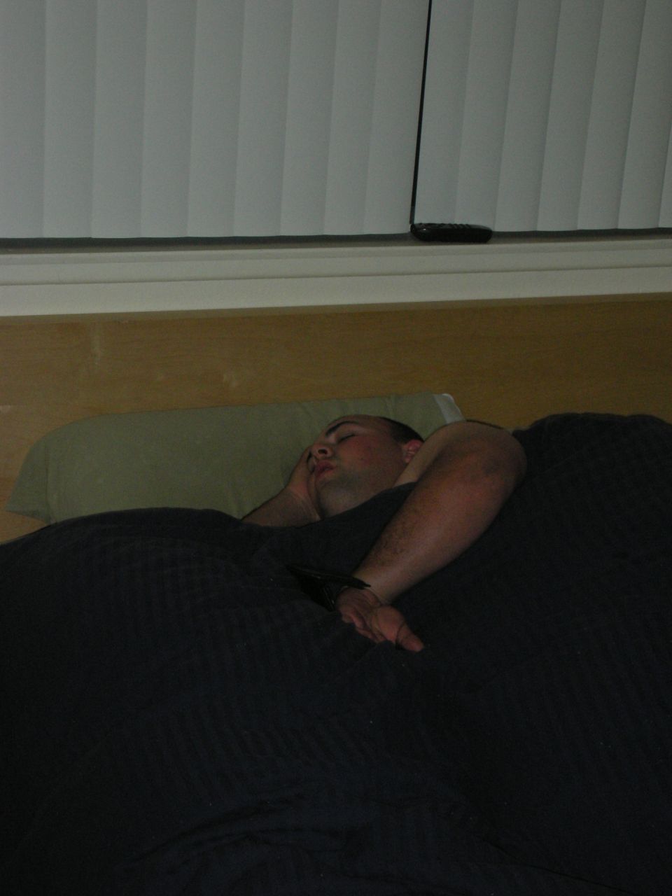 Man sleeping under a dark blue blanket