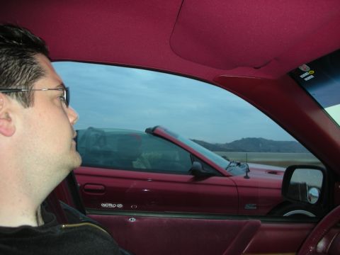 1992 Ford Crown Victoria - View from inside a car shows a red convertible driving on a highway next to it.