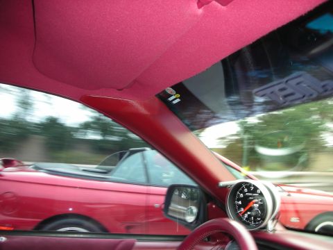 1992 Ford Crown Victoria - Interior view showing a dashboard gauge and a red convertible in motion.