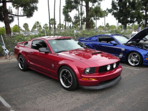 1992 Ford Crown Victoria - A red Ford Mustang is parked next to a blue Ford Mustang with its hood open.