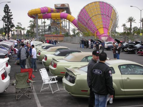 1992 Ford Crown Victoria - Several Ford Mustangs are parked at an outdoor event with a water slide structure visible.