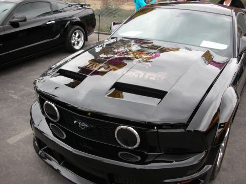 1992 Ford Crown Victoria - A black Ford Mustang is shown from the front, a custom hood with prominent scoops and distinctive circular headlights.