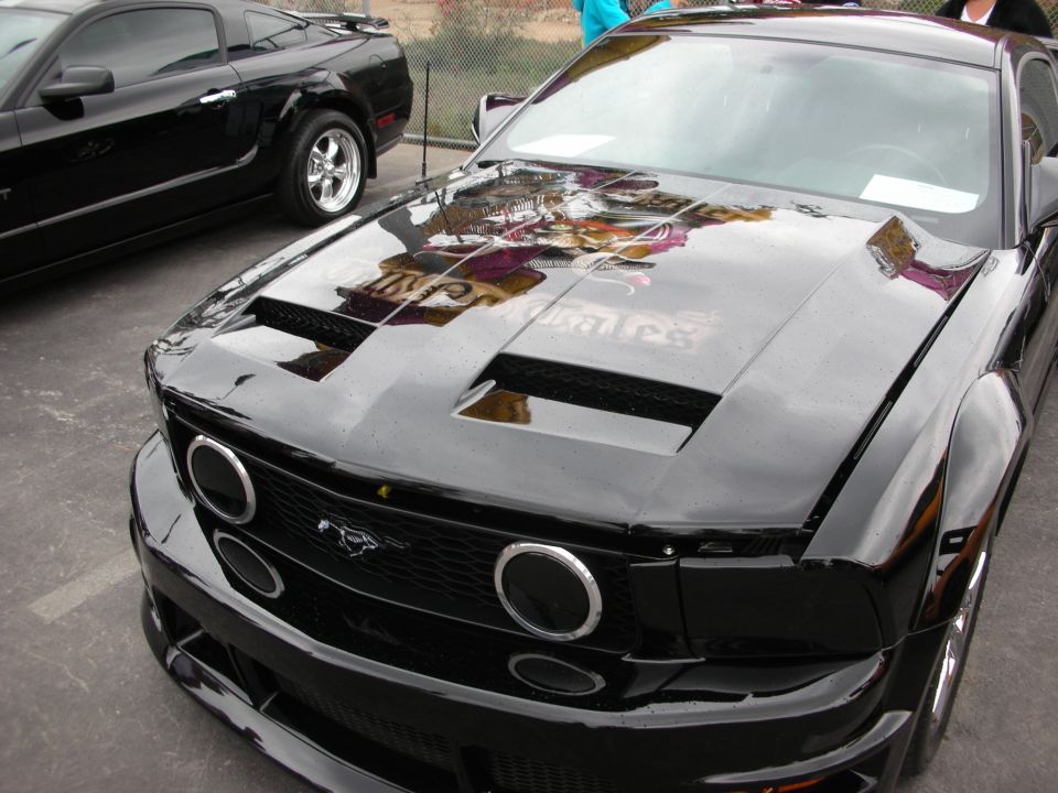 Black Ford Mustang front view with custom hood scoops and chrome ring headlights