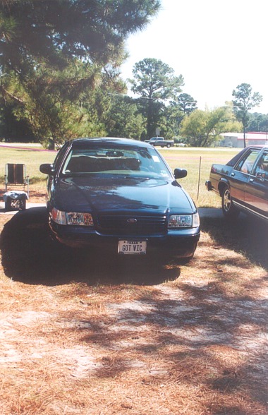2002 Ford Crown Victoria - A dark blue Ford Crown Victoria is parked outdoors on a sunny day, with another vehicle visible to its right.