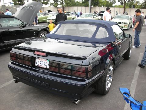 1992 Ford Crown Victoria - Rear view of a black Ford Mustang convertible at a car show.