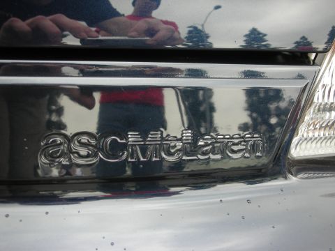 1992 Ford Crown Victoria - The ASC McLaren emblem is visible on the rear of the vehicle, reflecting the surroundings.