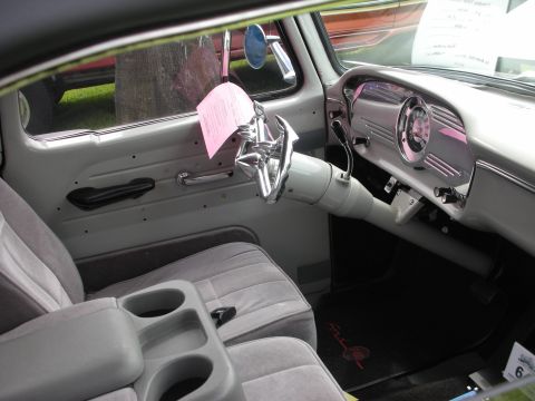 1992 Ford Crown Victoria - The interior of a classic truck features a custom steering wheel and a dashboard with a prominent circular speedometer.