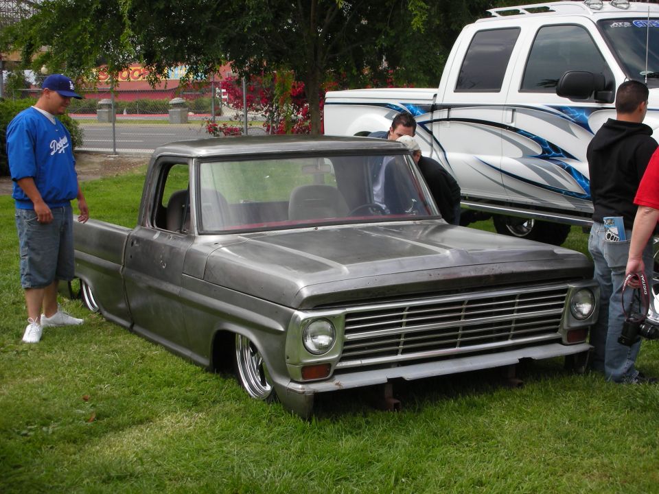 Gray pickup truck with chrome grille and lowered suspension, front view