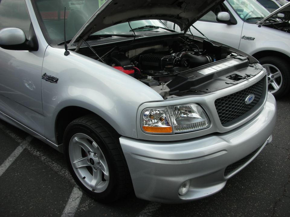 Silver 1999 Ford F-150 SVT Lightning pickup truck, front quarter view, hood open showing engine