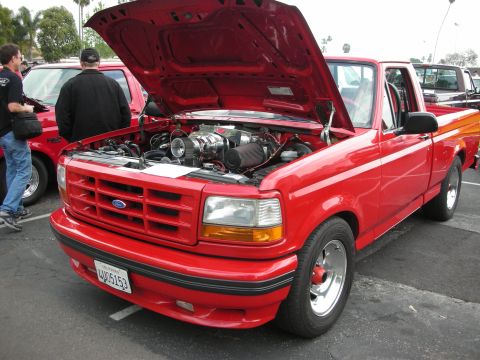 1992 Ford Crown Victoria - A red 1992 Ford F-150 pickup truck is displayed with its hood open, revealing a supercharger under the hood.